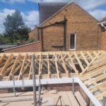 Timber roof structure being built on a house extension by carpenters in Nottingham.