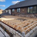 Timber roof structure being installed on a new house extension by carpenters in Nottingham.